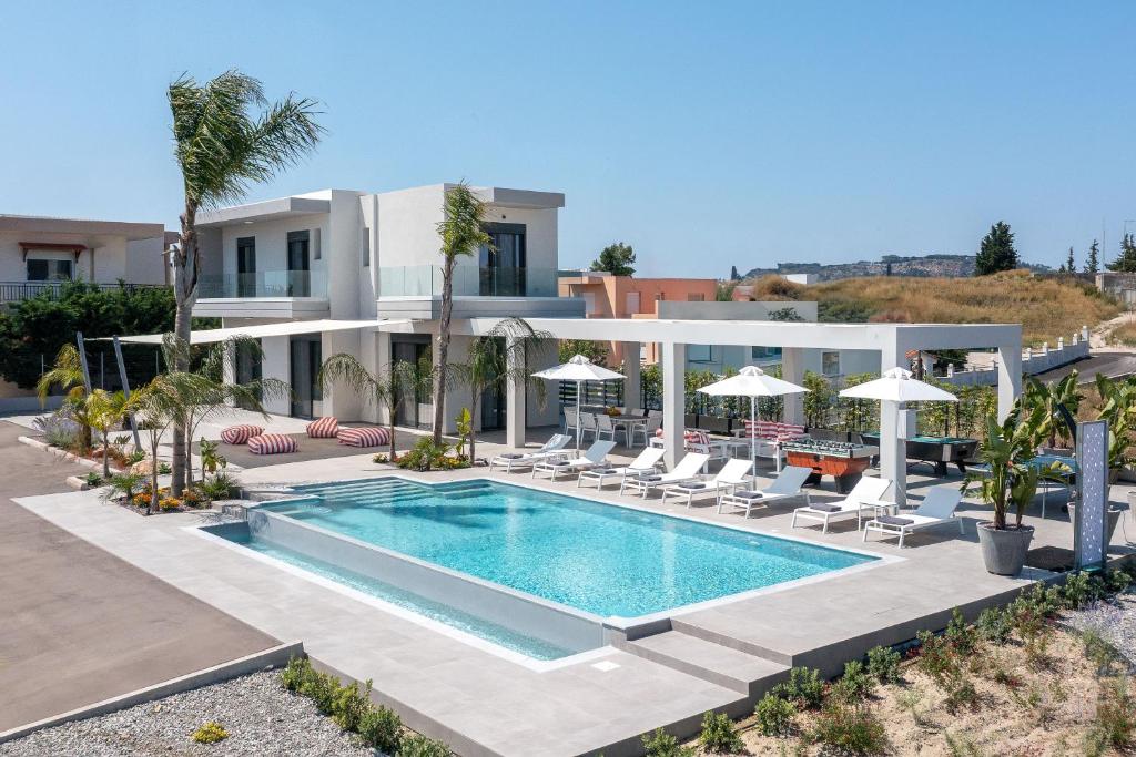 a villa with a swimming pool in front of a house at Villa Korali in Pastida