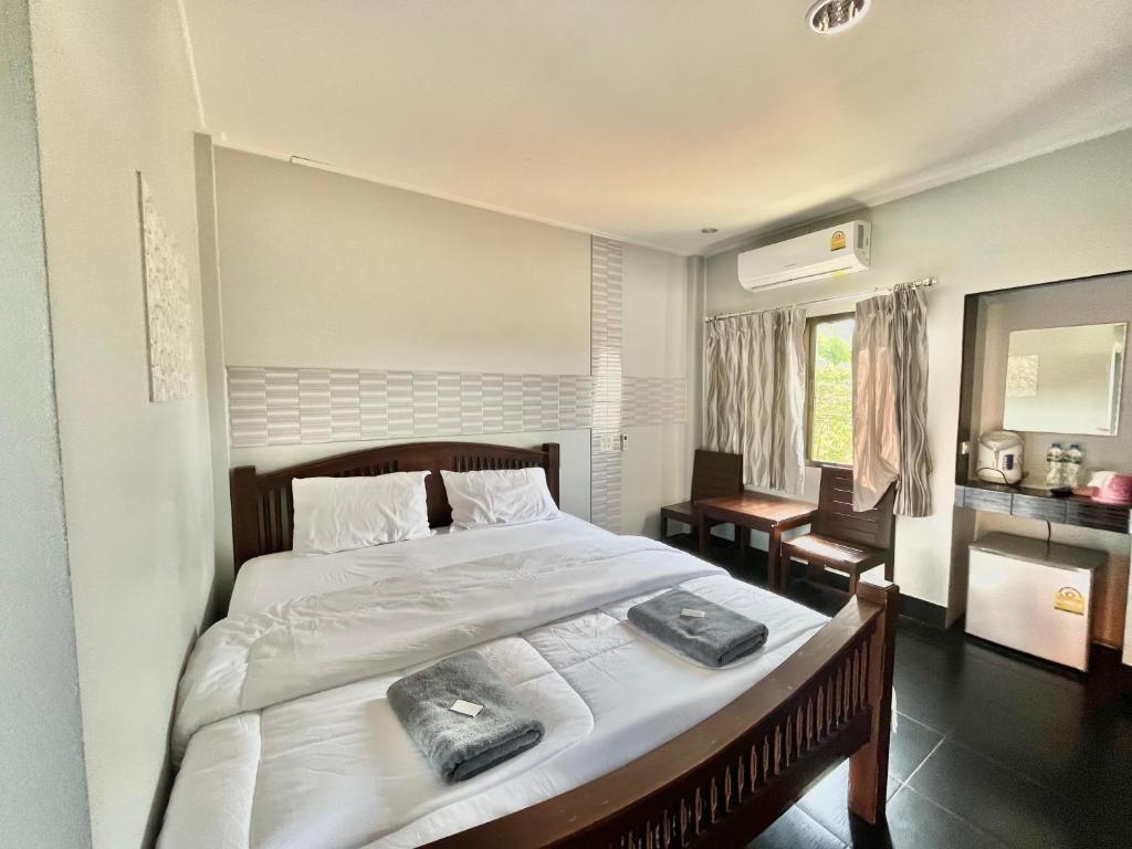 um quarto com uma cama grande com duas toalhas em J2 INN em Uttaradit
