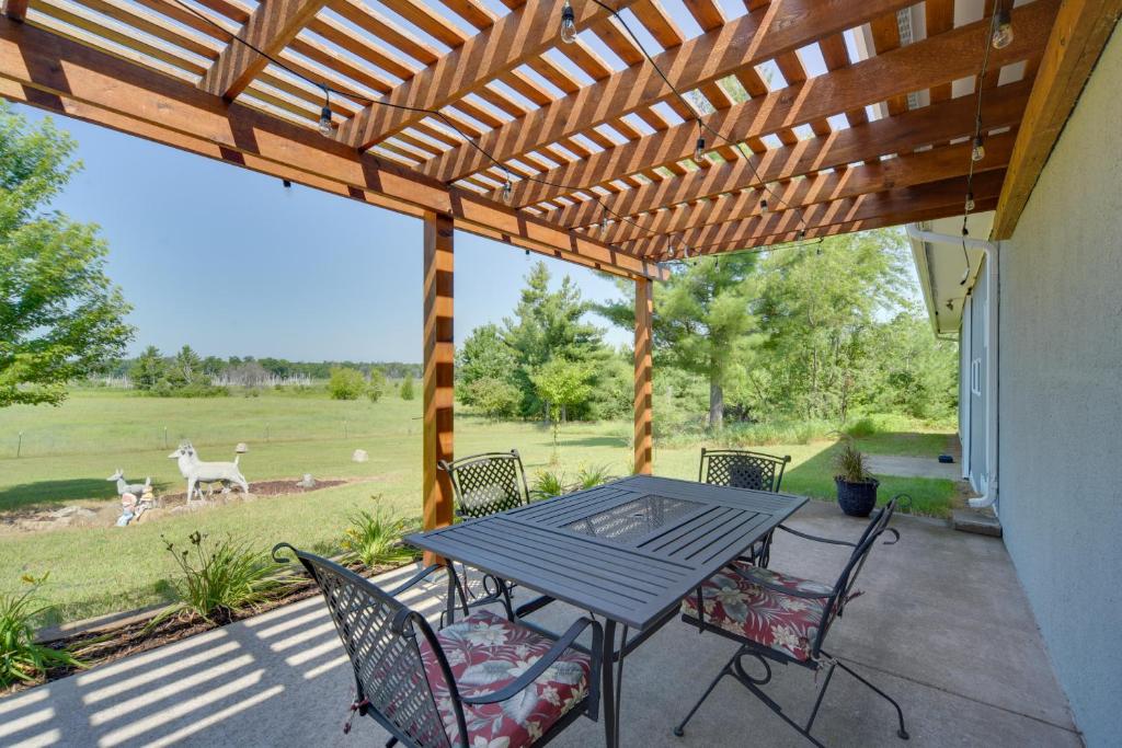 un patio con pergolato in legno, tavolo e sedie. di Natures Paradise Rustic Retreat in Wisconsin! 