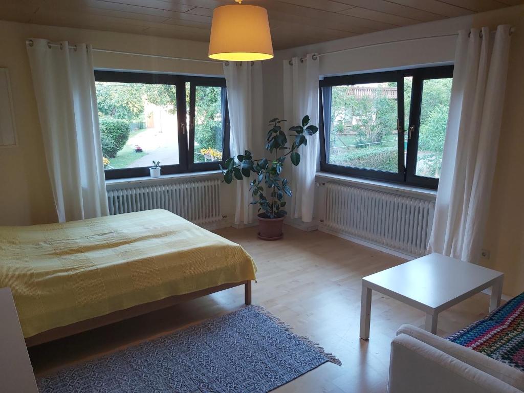 a bedroom with a bed and a couch and windows at Ferienwohnung im Molsbachtal in Happurg