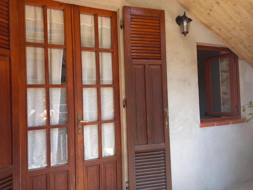 a pair of wooden doors and a window on a building at Domus Shardana in Gonnesa