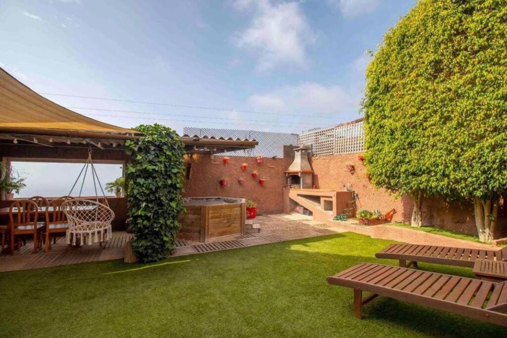 a backyard with a grill and a table and a bench at Villa Canales in La Matanza de Acentejo
