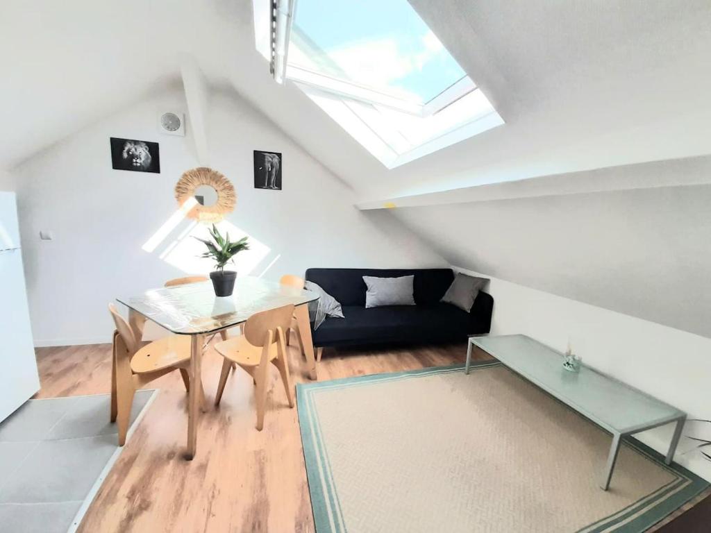 ein Wohnzimmer mit einem Tisch und einem Sofa in der Unterkunft Résidence du Houx - 6 (Astérix, Aéroport CDG...) in Survilliers