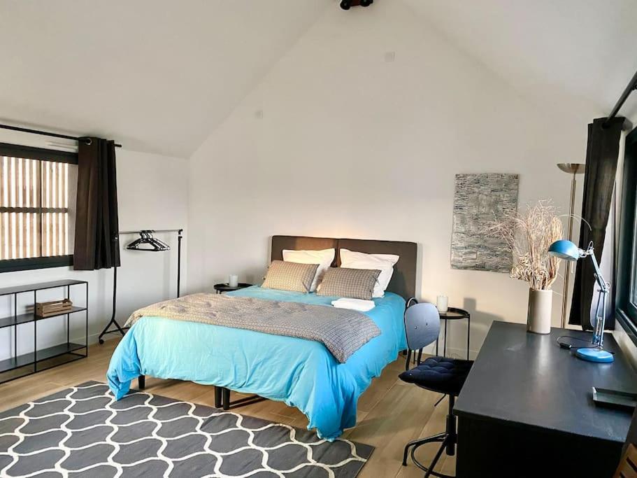 1 dormitorio con cama azul, escritorio y escritorio en Magnifique T2 neuf, proche gare, parking facile en Vannes