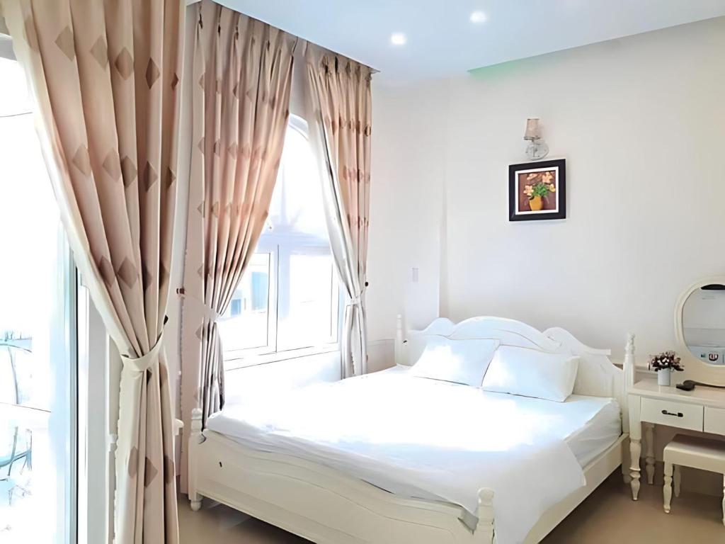 a white bedroom with a bed and a window at THIÊN ANH HOTEL in Vung Tau