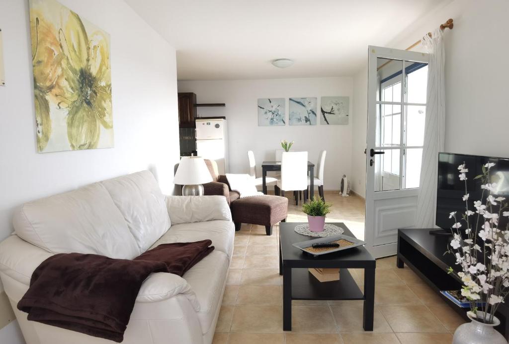Brisa del mar في لا سانتا: غرفة معيشة مع أريكة بيضاء وطاولة