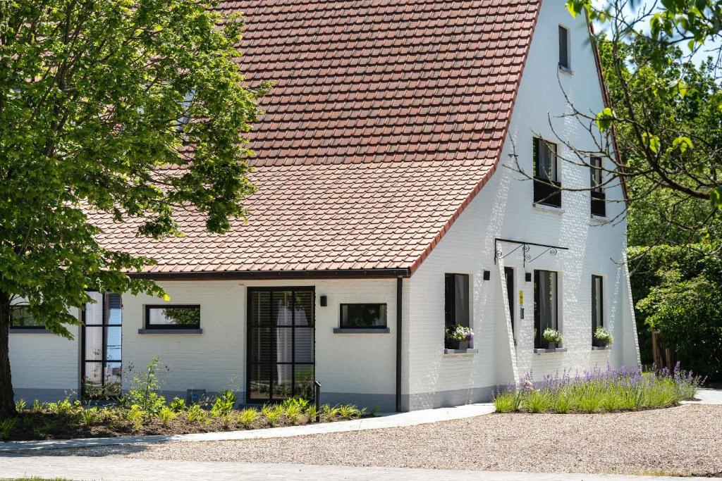 a white house with a red roof at De Gulle Beemden in Hulshout