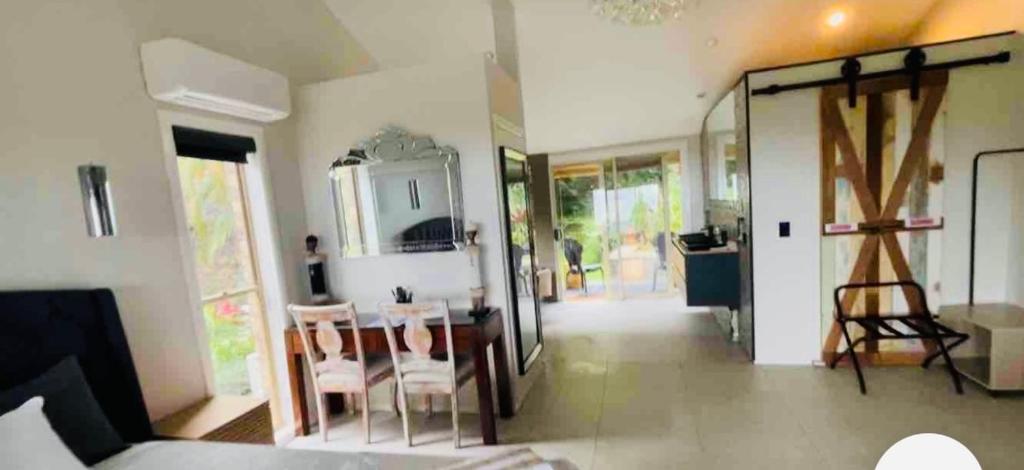 een kamer met een tafel en stoelen en een spiegel bij Como Guest Suite in Gold Coast