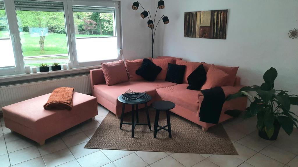 Ferienwohnung Am Kurpark في باد كامبيرغ: غرفة معيشة مع أريكة وردية وطاولة