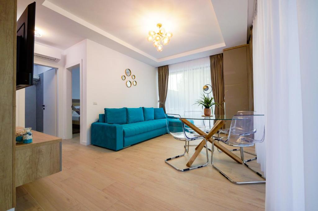 uma sala de estar com um sofá azul e uma mesa em Blue Luxury Apartment Lake On em Mamaia