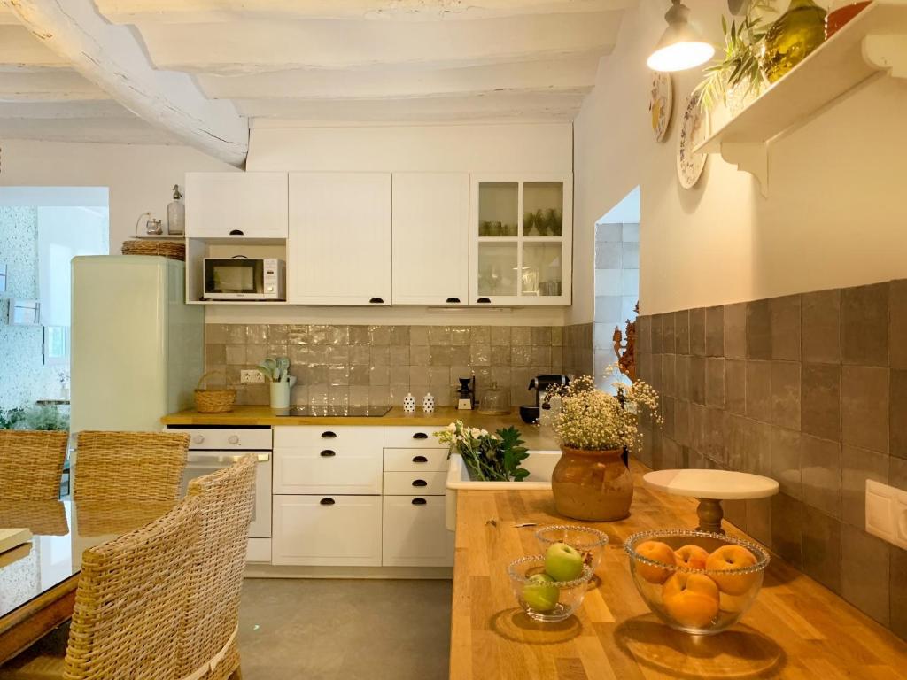 a kitchen with white cabinets and a wooden table at Syvyle in Cazorla