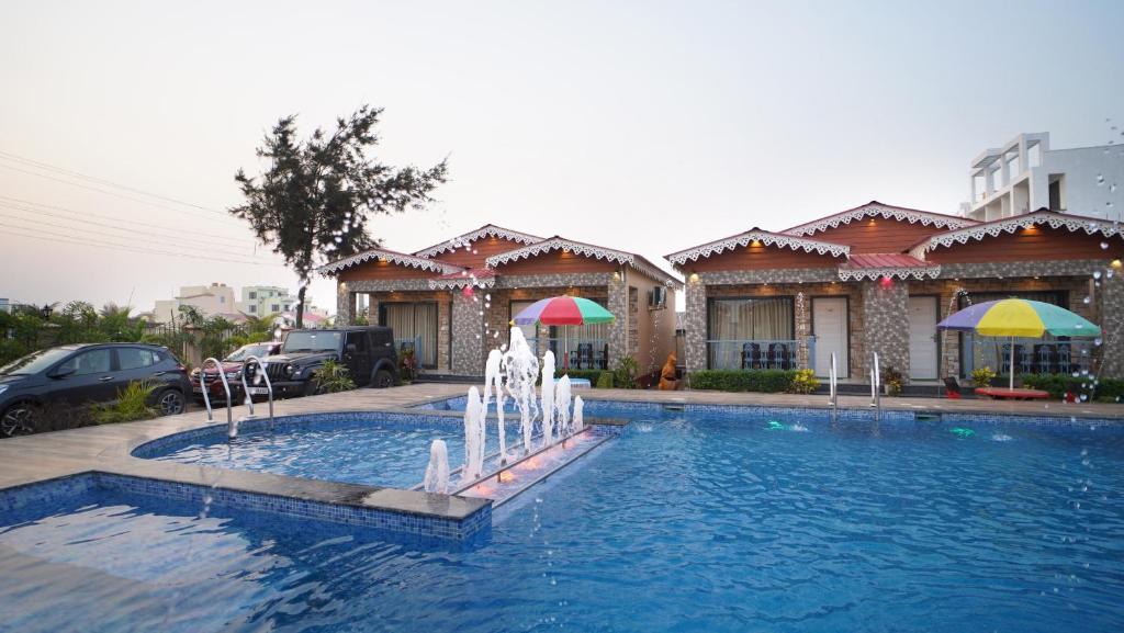 a swimming pool with a fountain in front of a building at AQUA BLUE RESORT PRIVATE LIMITED in Mandarmoni