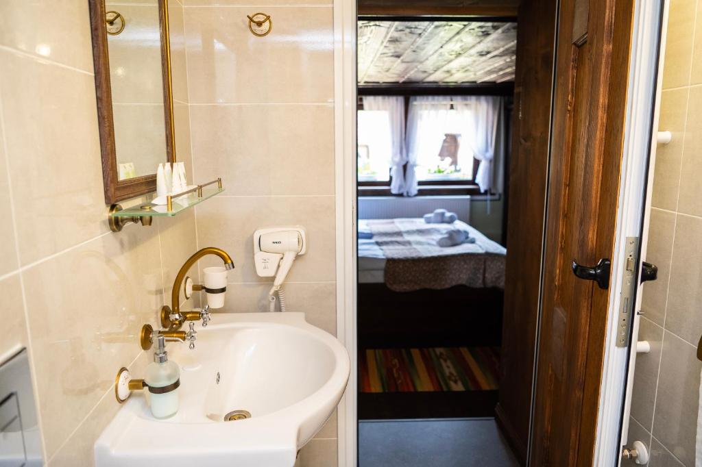 a bathroom with a sink and a mirror and a room at Къща ЕТНО in Koprivshtitsa