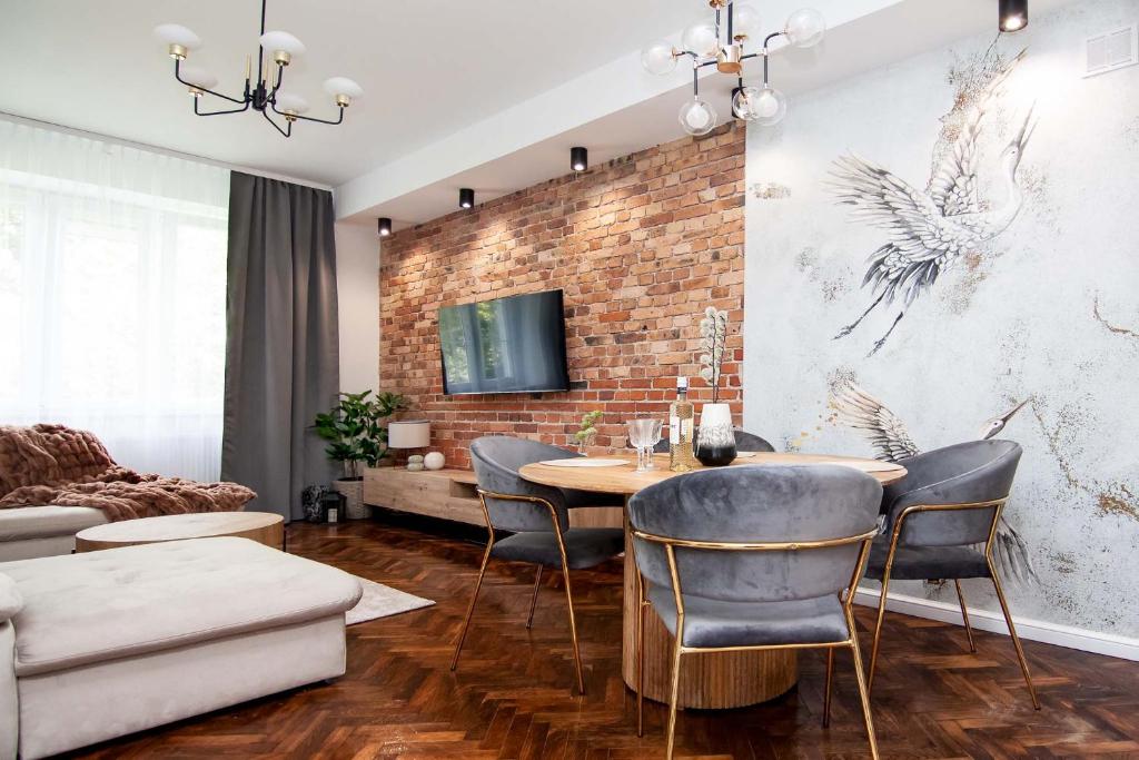 une salle à manger avec un mur en briques, une table et des chaises dans l'établissement Cztery Czaple, à Chełm