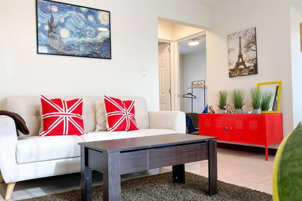 sala de estar con sofá blanco y almohadas rojas en Paseo de la Arboleda apartamento en Quetzaltenango