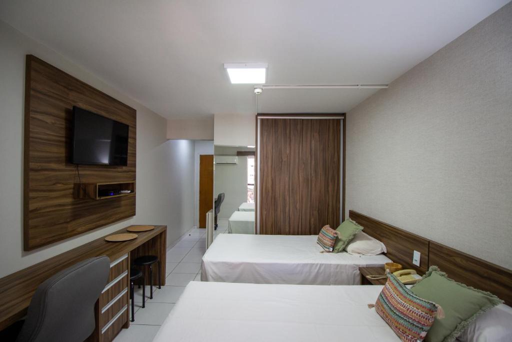 a hotel room with two beds and a television at Garvey Park Hotel in Brasilia