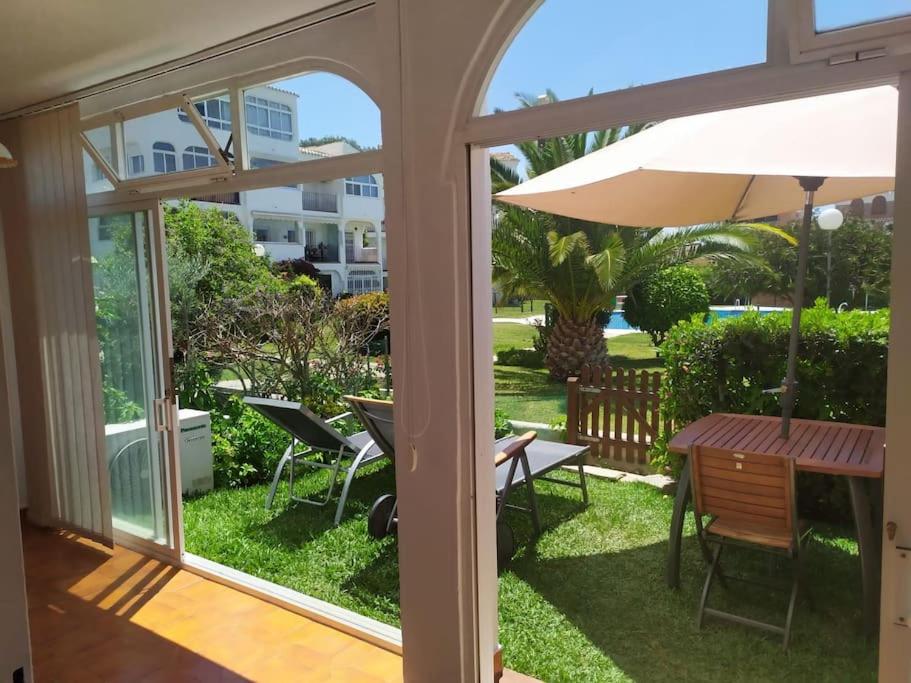 un patio con mesa y sombrilla en Coqueto apartamento en CalaHonda en Mijas Costa