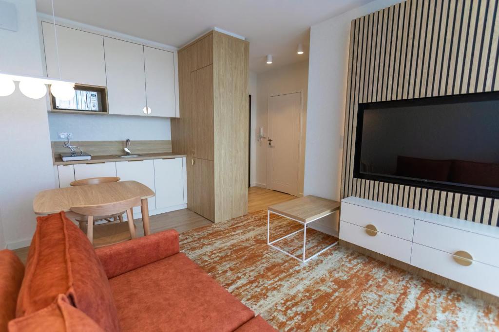 a living room with a couch and a flat screen tv at Bel Mare Aqua Resort B&M in Międzyzdroje