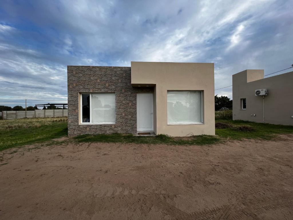 une maison assise sur un terrain de terre dans l'établissement DEPARTAMENTOS DEL GOLF, à Macachín