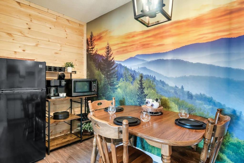 uma sala de jantar com uma mesa e um mural de montanha em Bear Pause Retreat/Steps to Pkwy/With Indoor Pool em Gatlinburg