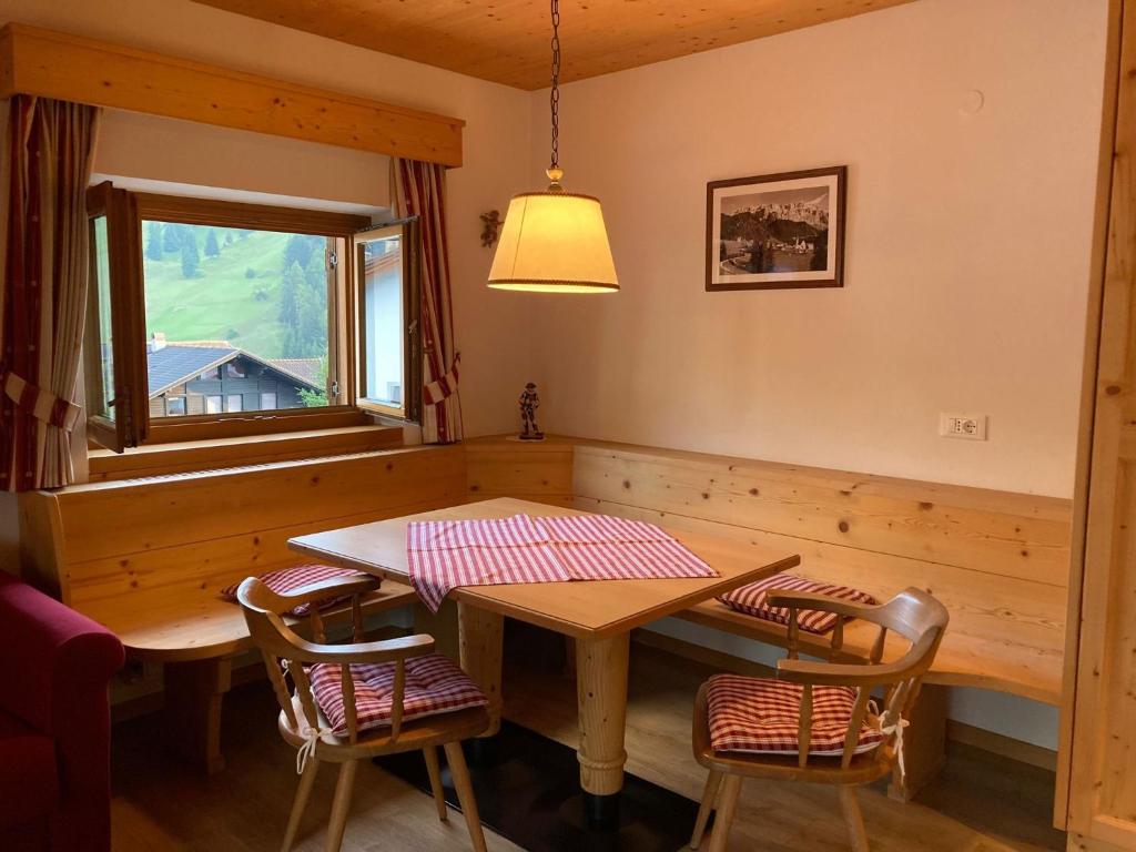 uma sala de jantar com uma mesa e cadeiras e uma janela em Week End Senoner em Selva di Val Gardena