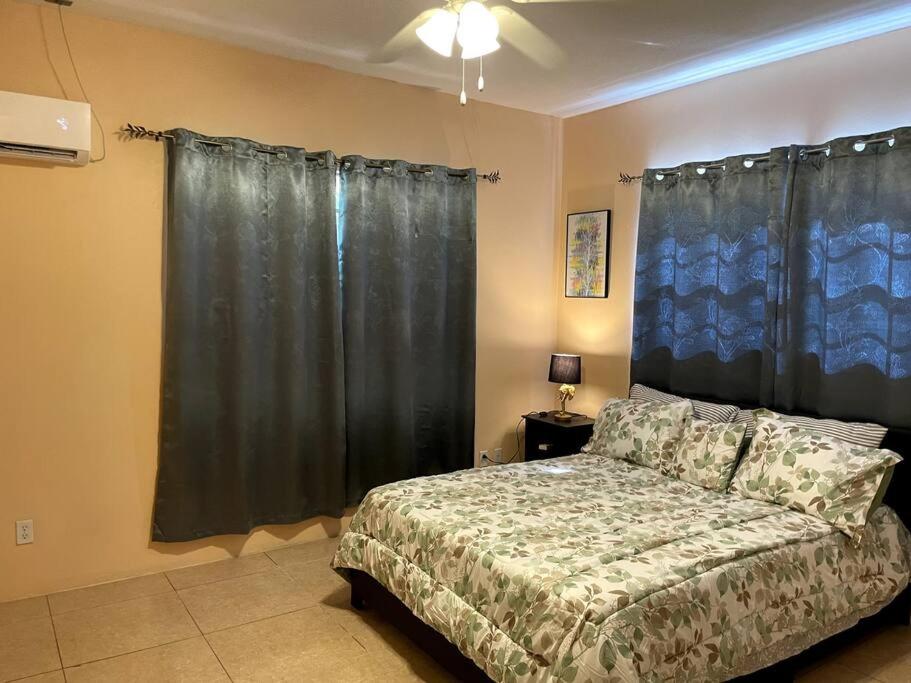 a bedroom with a bed and black curtains at Paradise Haven in Nassau