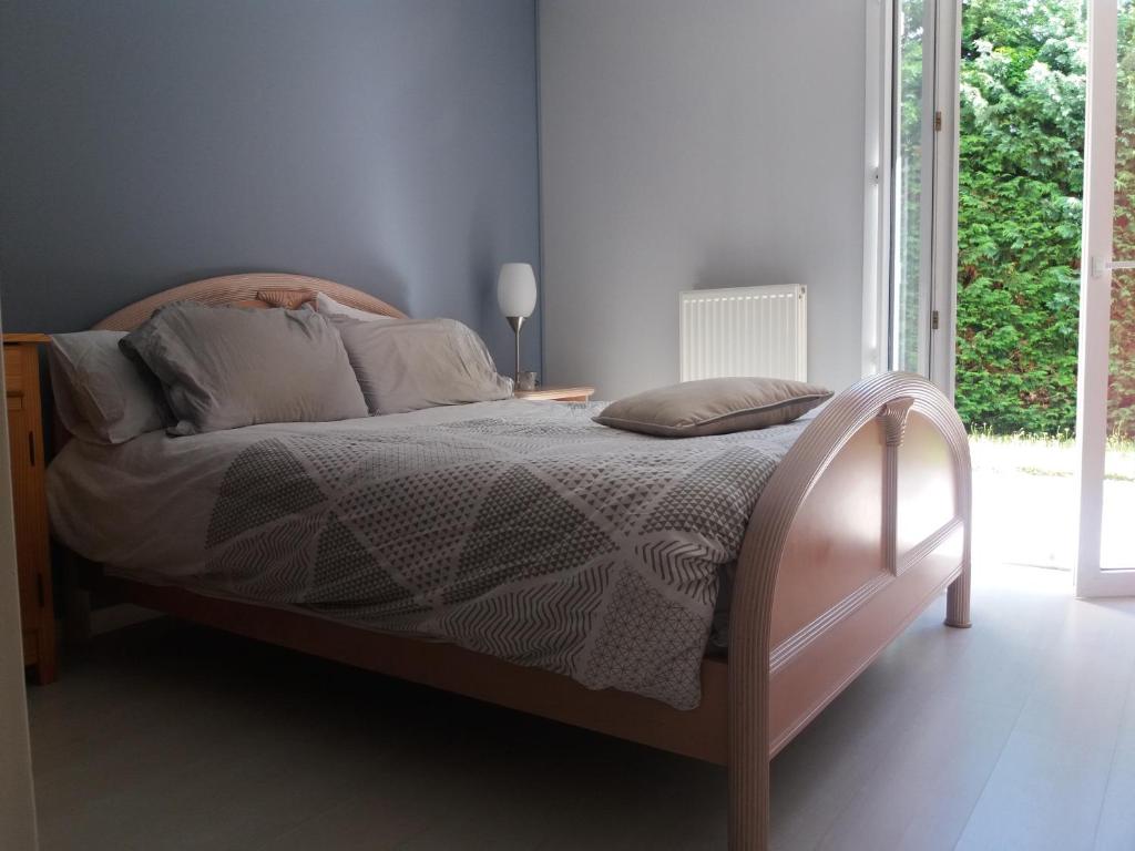- une chambre avec un lit avec un cadre en bois et une fenêtre dans l'établissement chambre dans maison avec piscine et cuisine, à Saint-Étienne