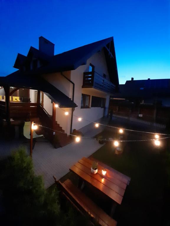 a night view of a patio with a wooden bench at Domek u Jaśka in Głębokie