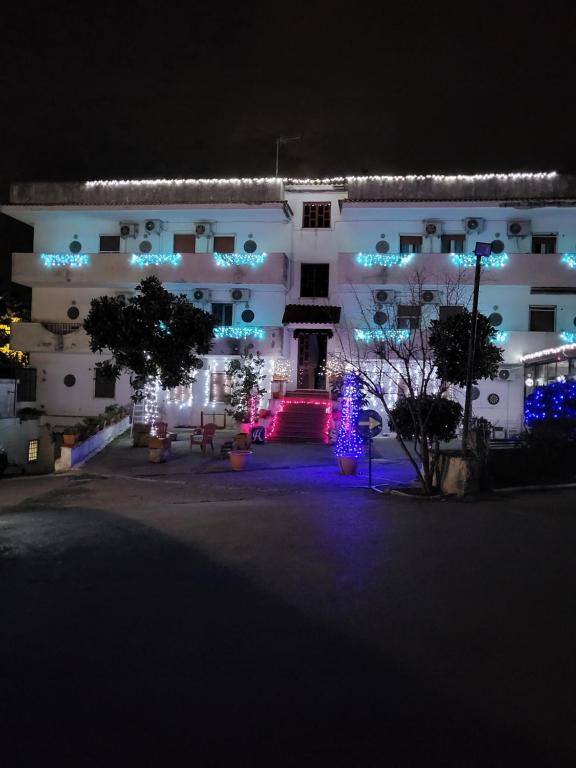 Hotel Souvenir في إيركولانو: مبنى أبيض مع أضواء عيد الميلاد أمامه