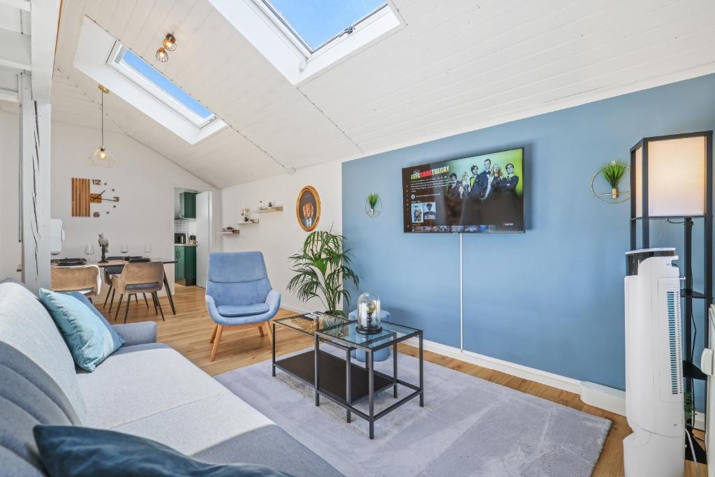 ein Wohnzimmer mit einem weißen Sofa und einer blauen Wand in der Unterkunft apart21 - Blue - zentrale Maisonette-Wohnung Parkplatz Netflix nahe Audi in Ingolstadt