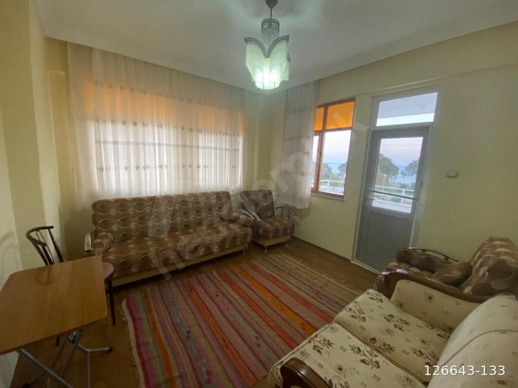 ein Wohnzimmer mit Sofas, einem Tisch und einem Fenster in der Unterkunft Finike Apart in Finike