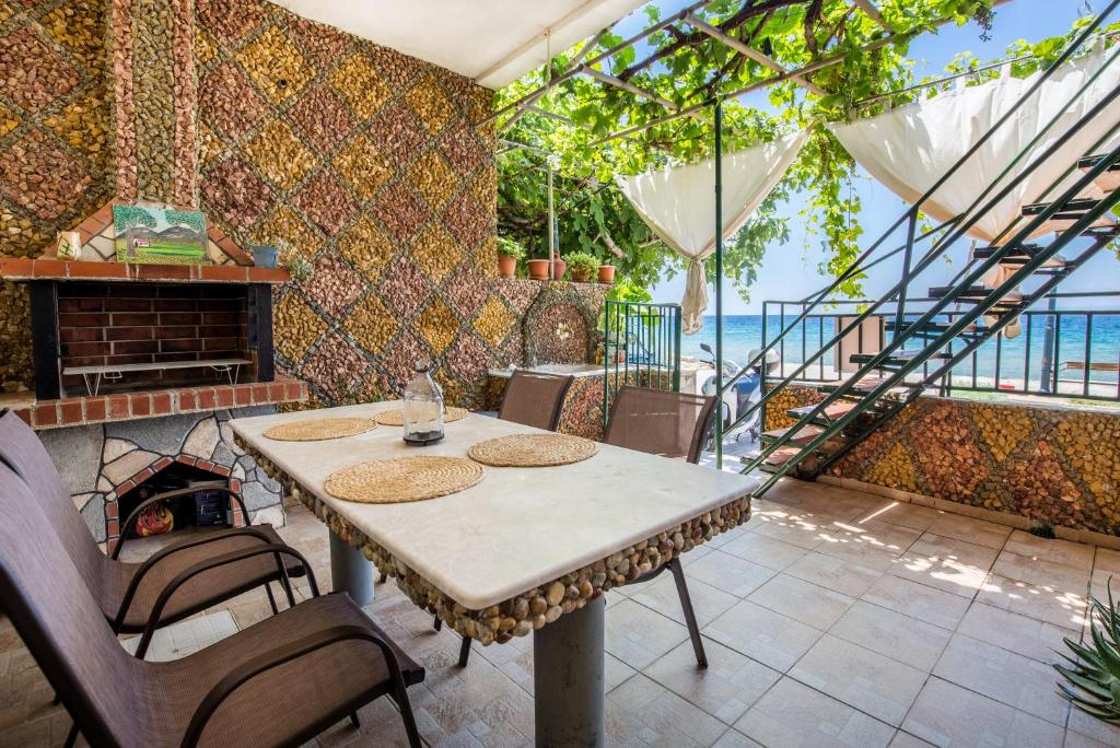 ein Esszimmer mit einem Tisch und einem Kamin in der Unterkunft Golden Sunset Beach Apartment in Skala Kallirachis