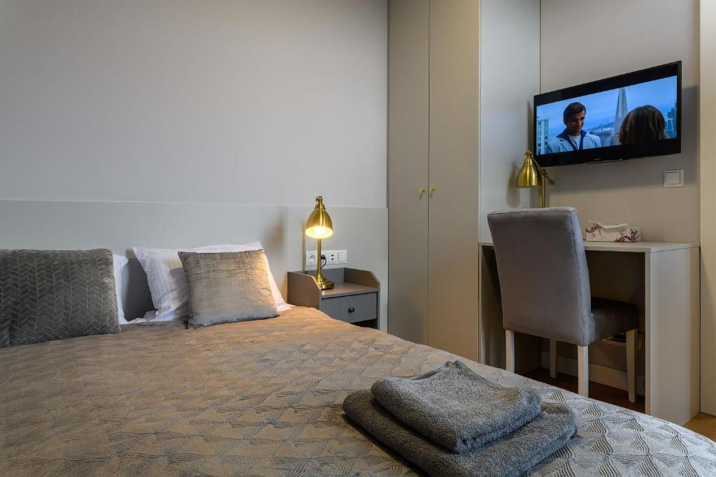a bedroom with a bed and a desk and a television at Niebieski Horyzont in Jastrzębia Góra