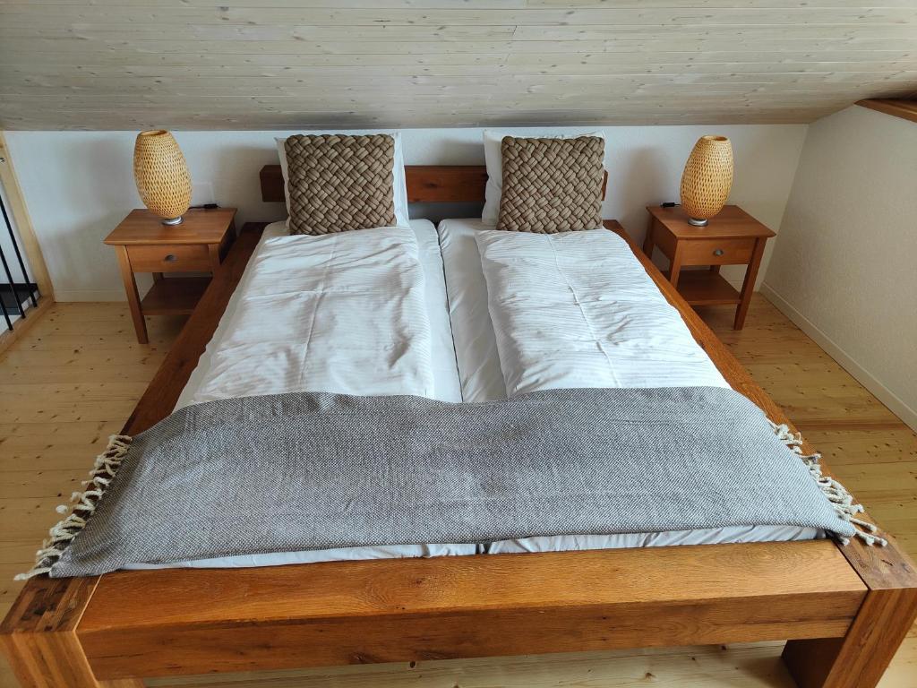 ein großes Bett in einem Zimmer mit 2 Tischen in der Unterkunft la maisonette in Saignelégier