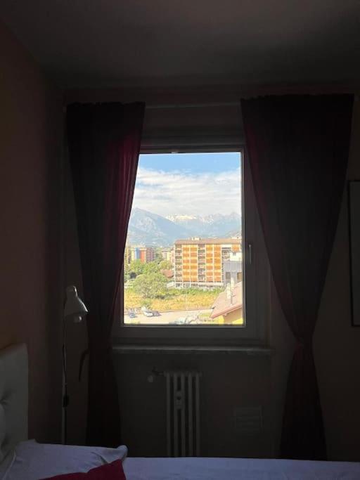 a window in a bedroom with a view of a city at Casa Verena in Aosta