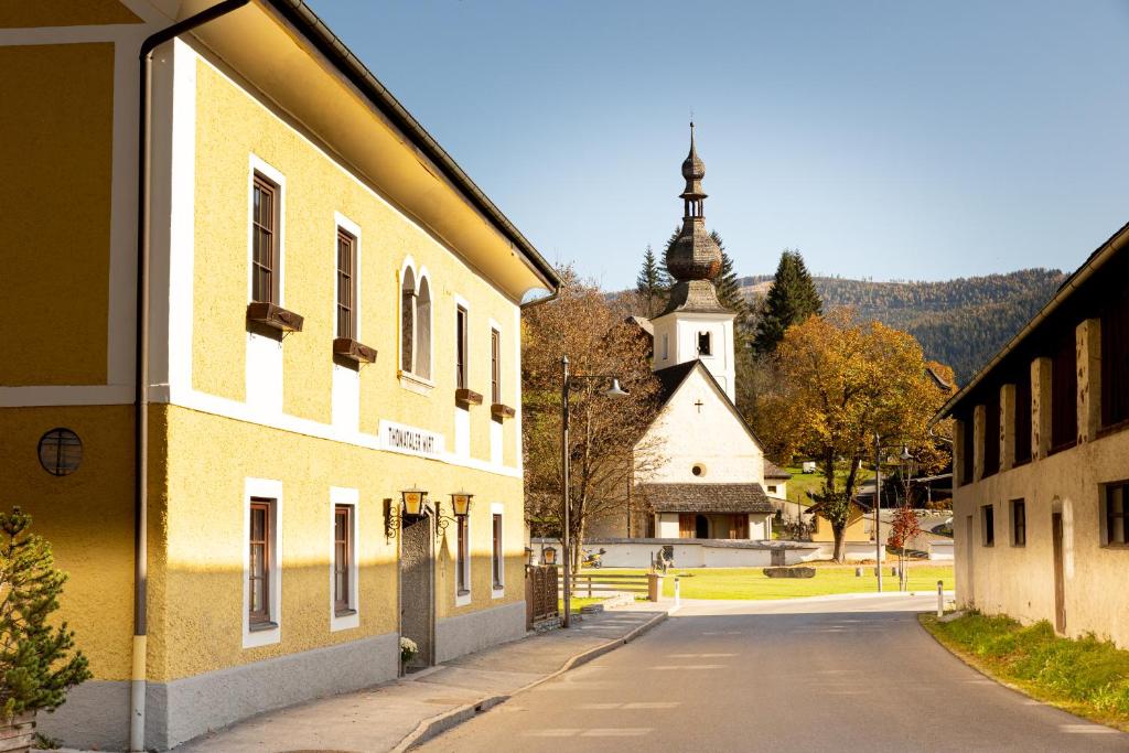 eine leere Straße vor einem Gebäude mit einer Kirche in der Unterkunft Der Thomataler Wirt in Thomatal