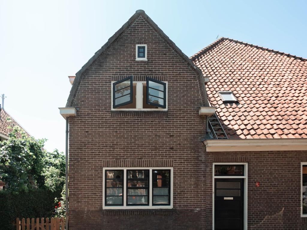 a brick house with two windows and a roof at Bed and breakfast Jan in Edam