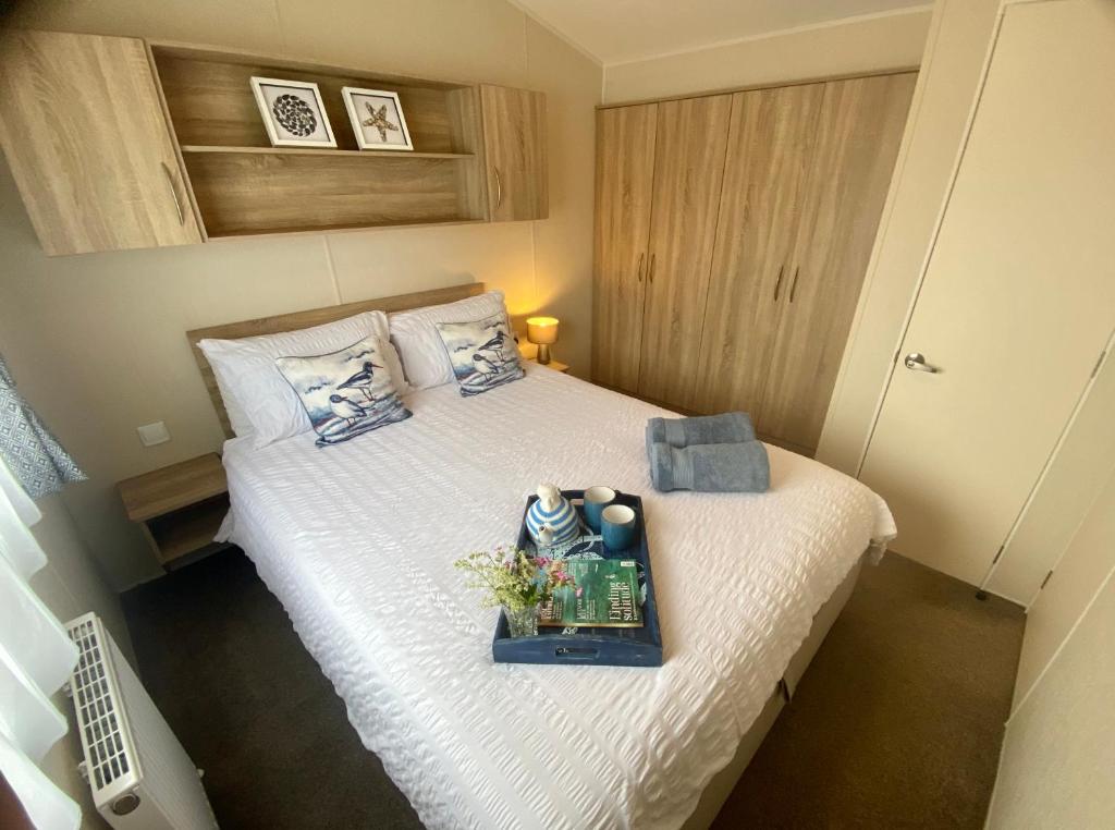 a small bedroom with a bed with a tray on it at Gannets Rest - Spacious Static Caravan with Sea Views in Polperro
