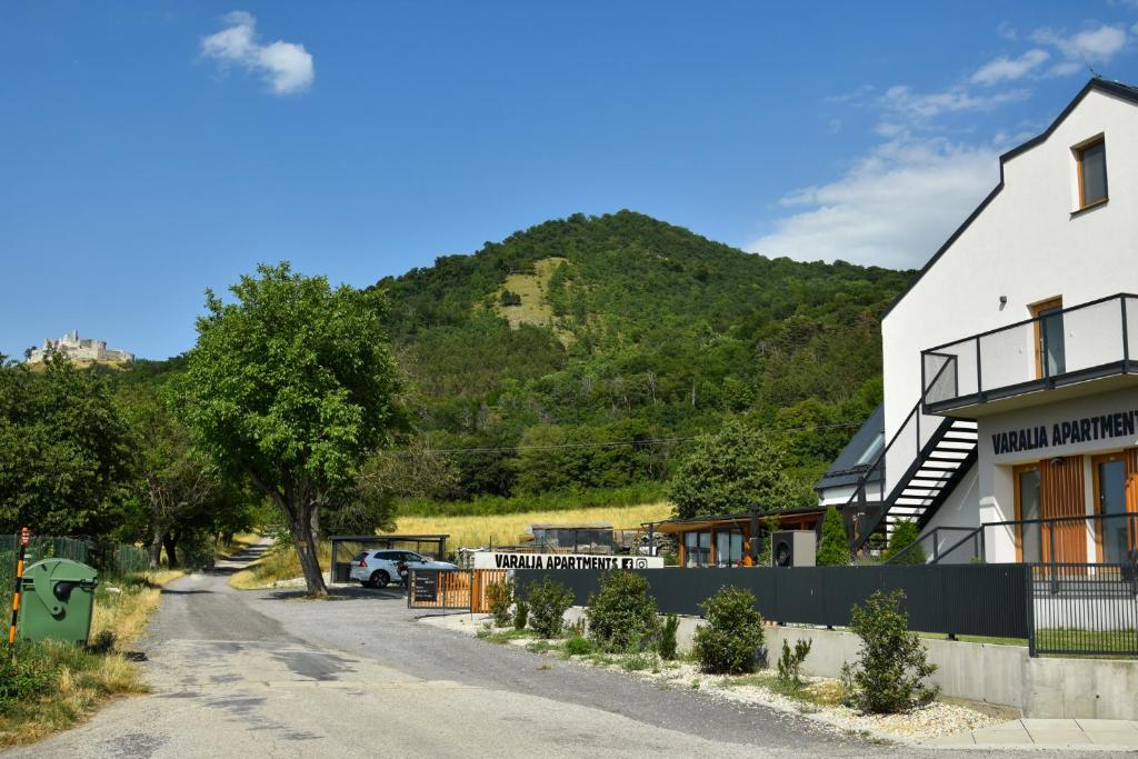 a house on the side of a road with a mountain at Varalja Apartments in Plavecké Podhradie