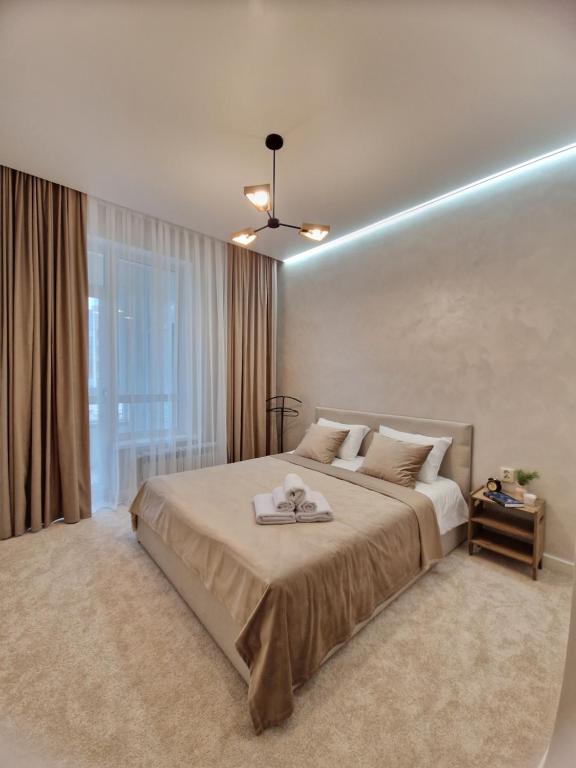 a bedroom with a large bed with a light on it at Expo Residence Astana in Astana