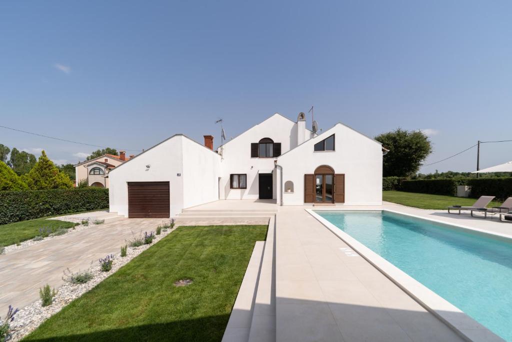 eine Villa mit Swimmingpool und ein Haus in der Unterkunft Villa Bosa in Poreč
