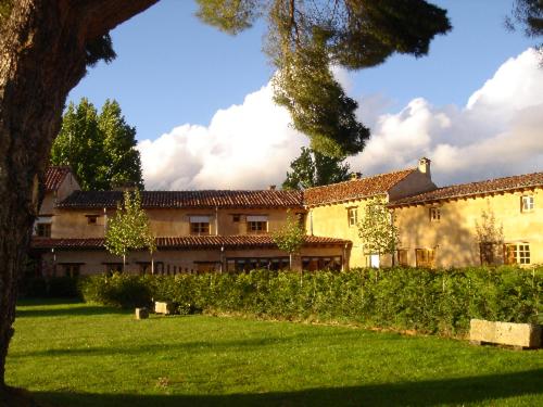 une grande maison dans une cour avec de l'herbe verte dans l'établissement El Jardin de la Huerta, à Sahagún