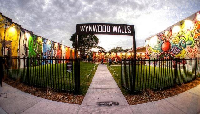 a fence with a sign in front of a building with graffiti at OQP Vacations Edgewater in Miami