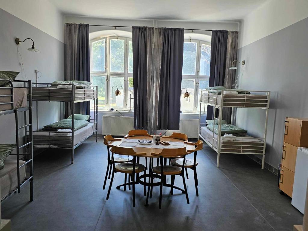 a room with a table and chairs and bunk beds at Stora Ekeberg vandrarhem in Axvall