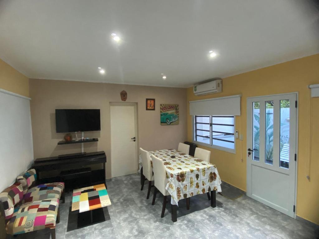a living room with a table and chairs and a piano at Apartamento de luxe centro in Chascomús