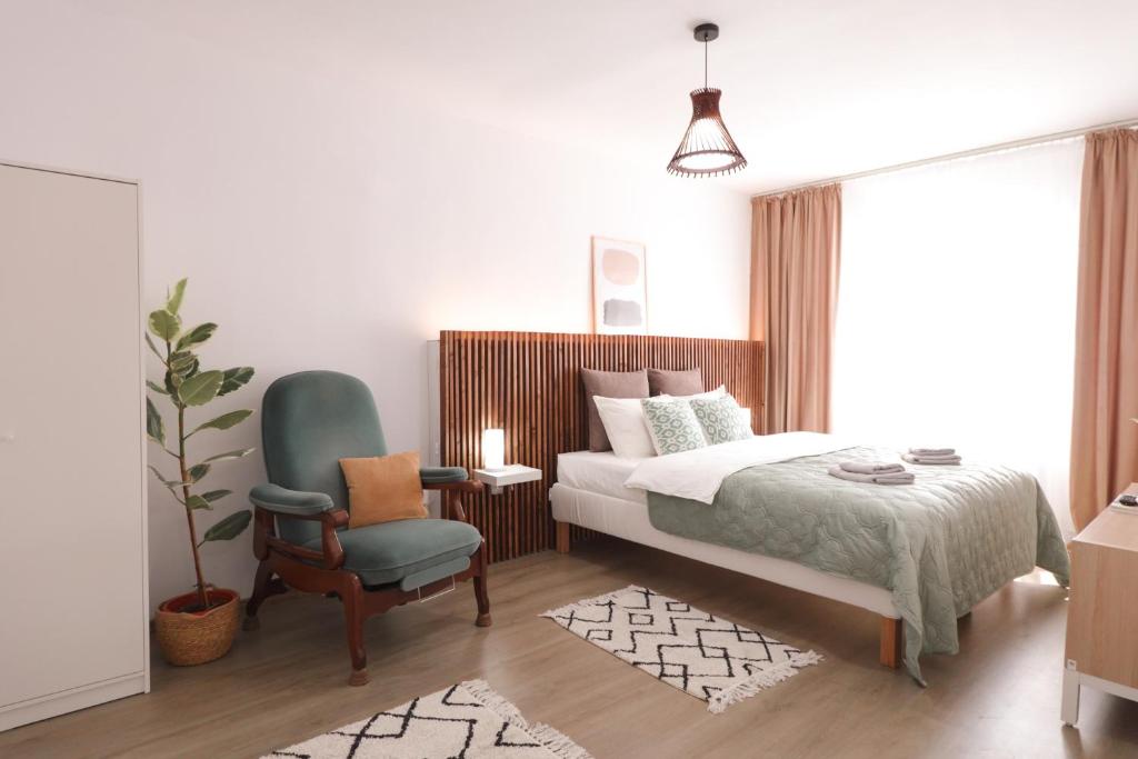 Un dormitorio blanco con una cama y una silla. en Hannah's Apartment Ocna Mures, en Ocna-Mureşului