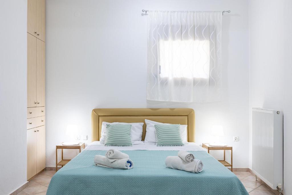 1 dormitorio con 2 toallas en una cama en The Olympus Garden Beach House en Litochoro