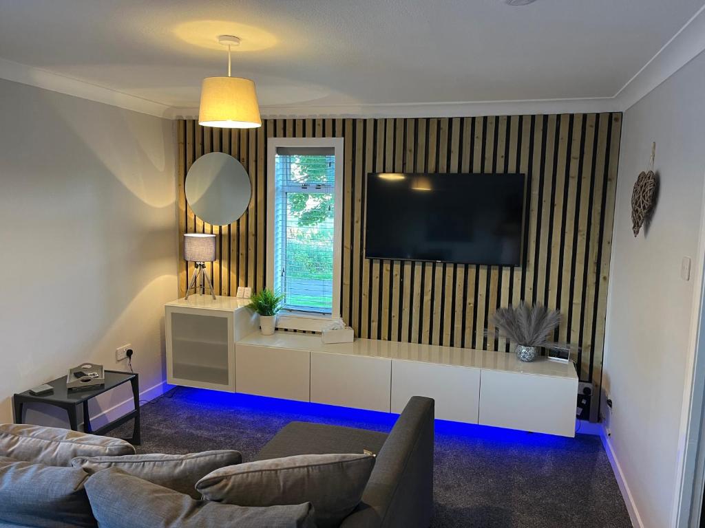 a living room with a couch and a flat screen tv at Erskine Apartment in Erskine