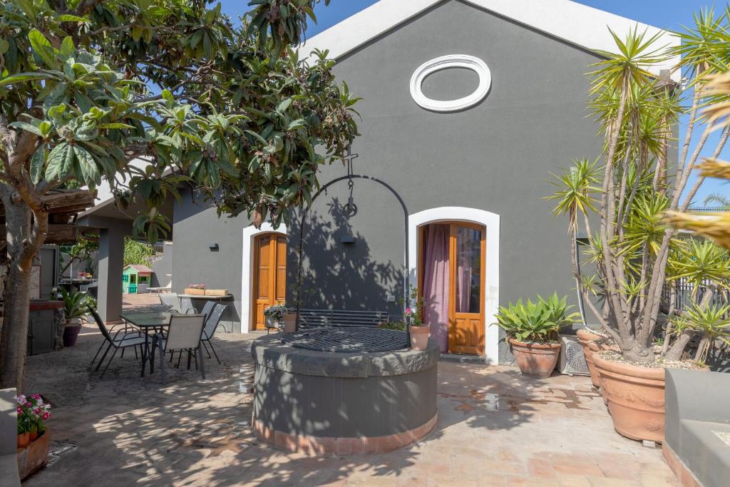 a house with a courtyard with a table and chairs at Villa Rose Acireale Santa Tecla in Santa Tecla