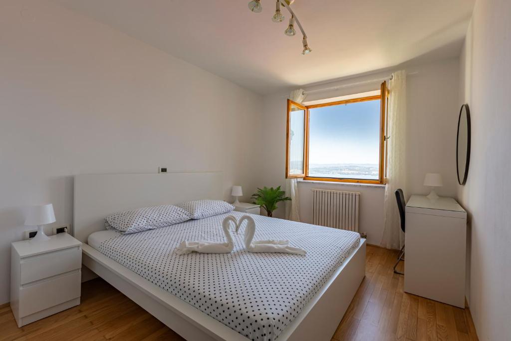 Un dormitorio blanco con una cama con dos cisnes. en Villa Andrea en Koper